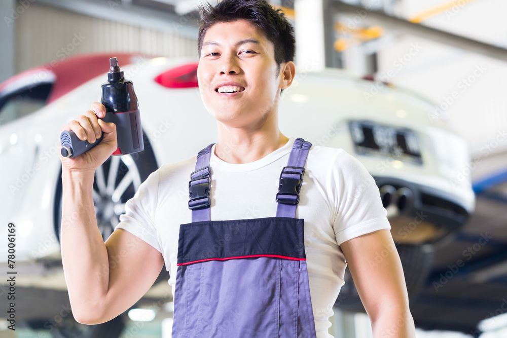 Car mechanic with tool in Asian Chinese auto workshop Car mechanic with tool in Asian Chinese auto workshop