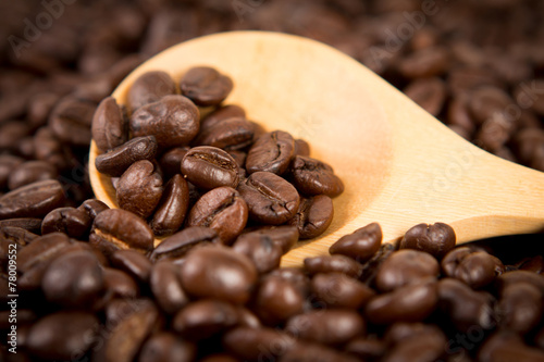 roasted coffee beans in wooden spoon  selective focus