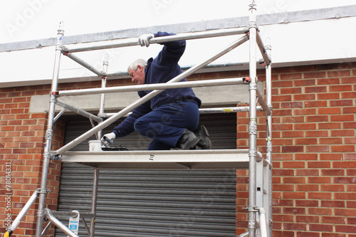 A painter working from a scaffold tower