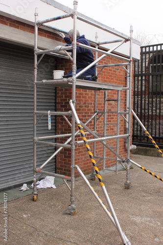 A painter working from a scaffold tower