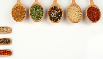Fototapete Gewürze Different spices and herbs in wooden spoons isolated on white  © Africa Studio