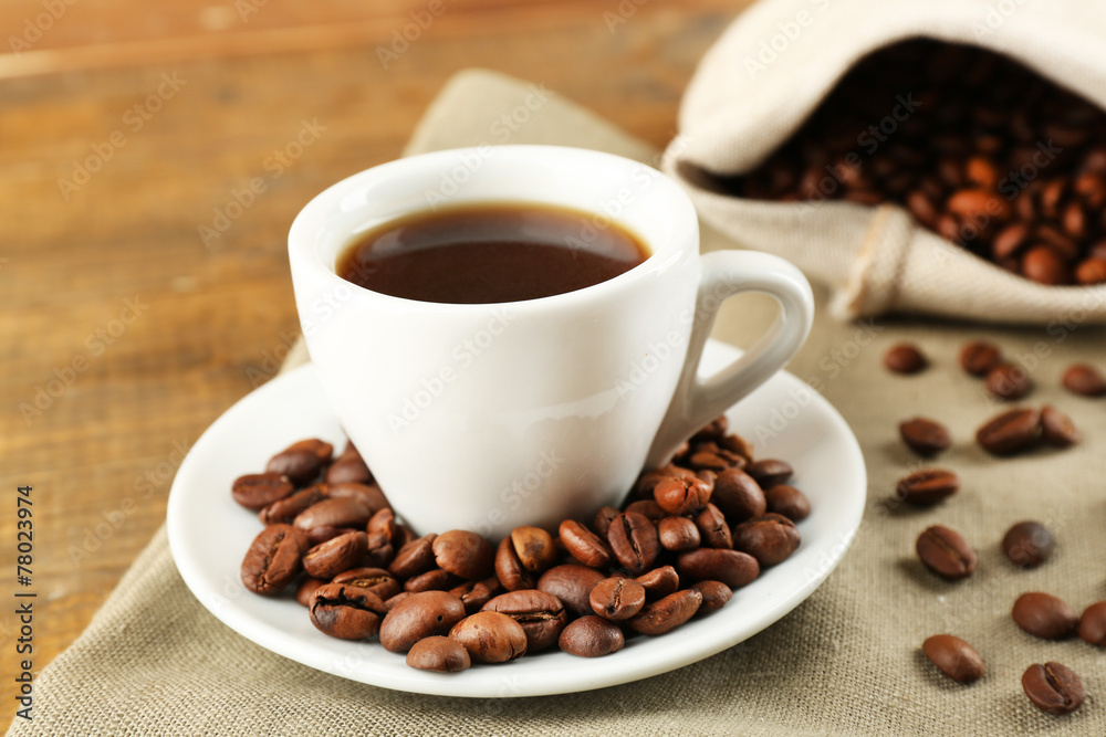 Cup of coffee with beans on rustic wooden background Cup of coffee with beans on rustic wooden background