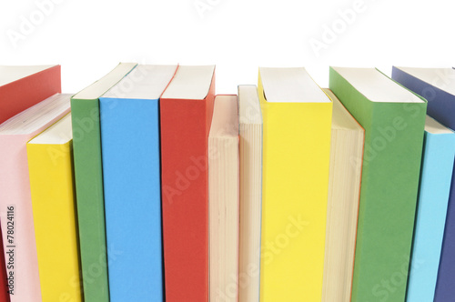 Row line of colorful books spine facing isolated white background photo