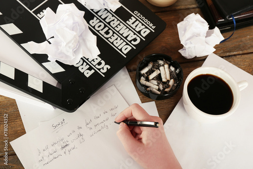 Tableau sur toile Female hand writing script at desktop with moving clapper and