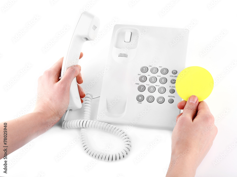 Female hand holding phone receiver isolated on white