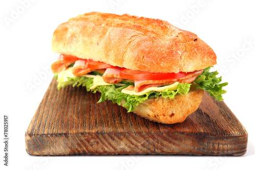 Fresh sandwich on wooden cutting board isolated on white