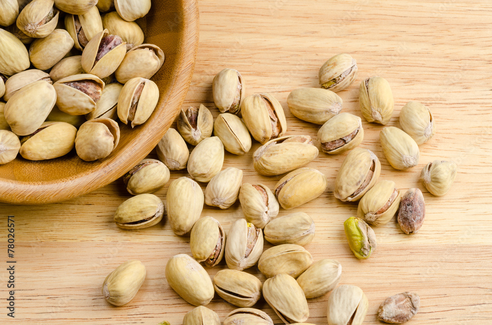 roasted and salted pistachios on wooden background roasted and salted pistachios on wooden background