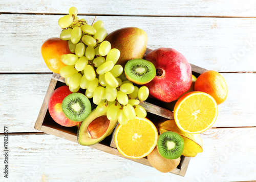 Assortment of fruits in box on wooden table