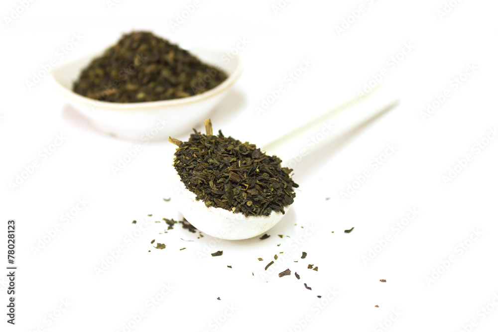 green tea leaves on spoon isolated on white background green tea leaves on spoon isolated on white background