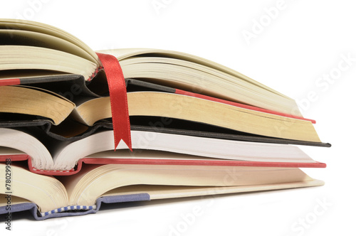 Untidy stack or pile of open books isolated white background photo