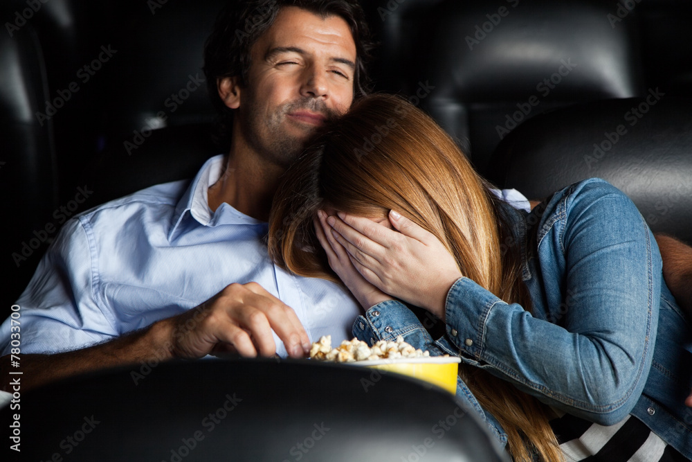 Naklejka premium Frightened Woman Leaning On Man In Cinema Theater