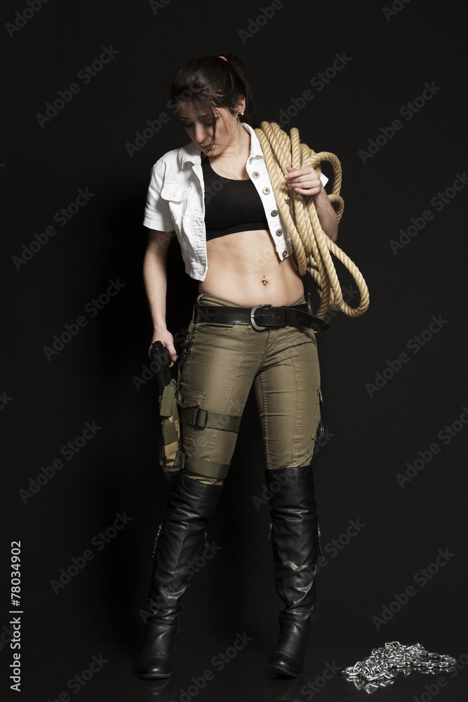 Fototapeta premium Frau mit Waffen vor dunklem Hintergrund