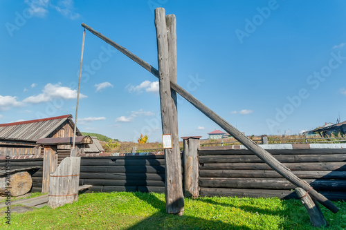 Old wooden water crane well in village photo