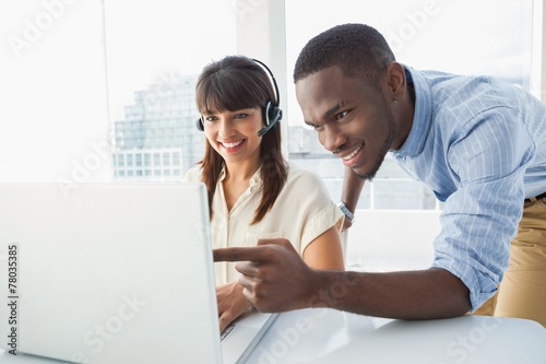 Smiling team using laptop and headset © WavebreakmediaMicro