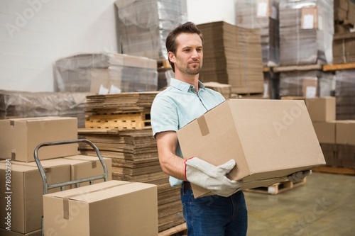 Obraz na plátně Worker carrying box in warehouse