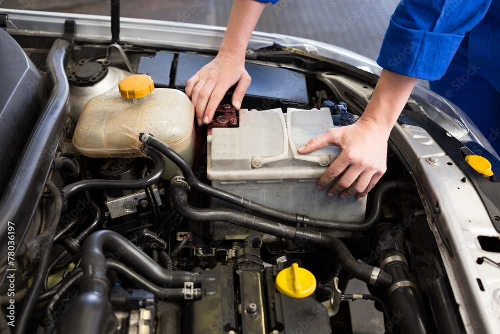 Mechanic examining under hood of car