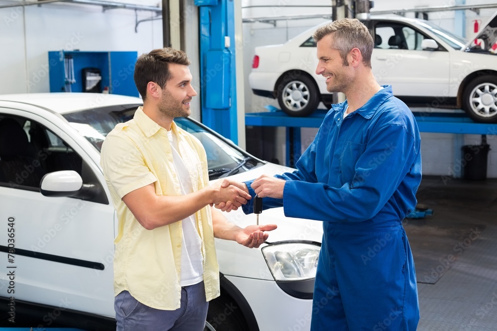 Customer shaking hands with mechanic taking keys