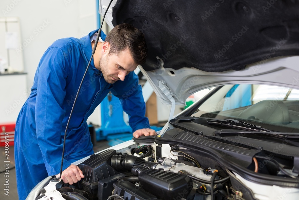 Mechanic examining under hood of car Mechanic examining under hood of car