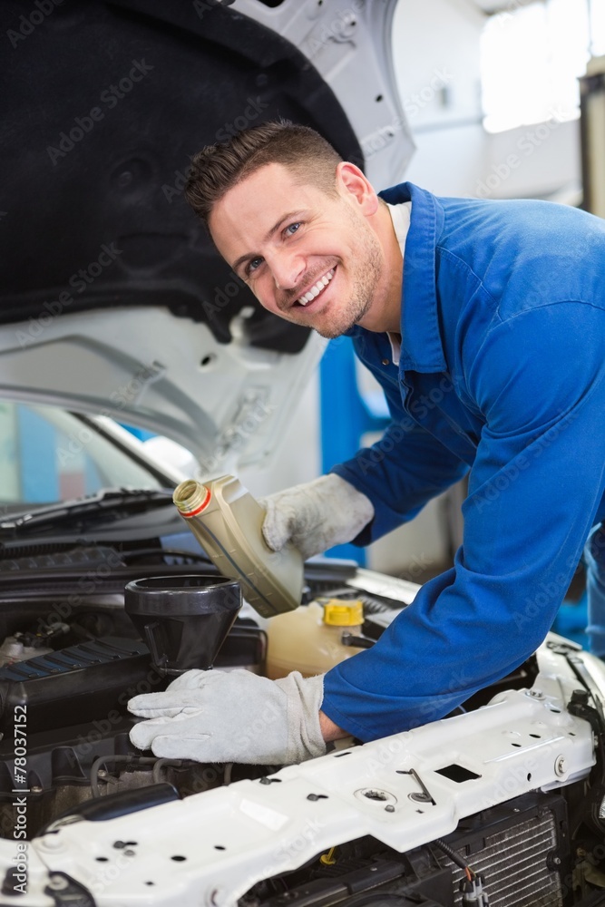 Mechanic pouring oil into car Mechanic pouring oil into car