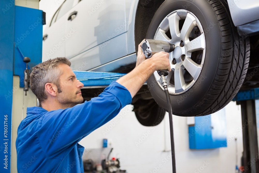 Mechanic adjusting the tire wheel Mechanic adjusting the tire wheel