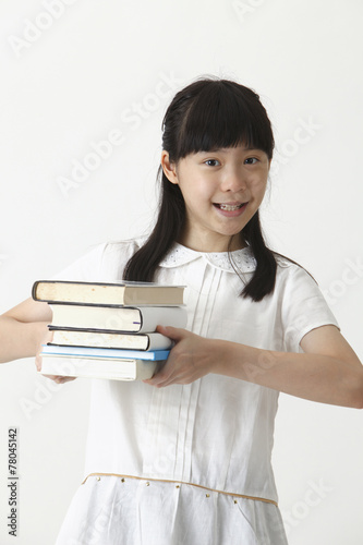 girl holding stack of books