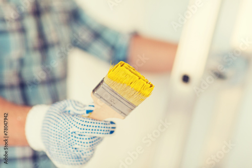 Φωτογραφία close up of male in gloves holding paintbrush