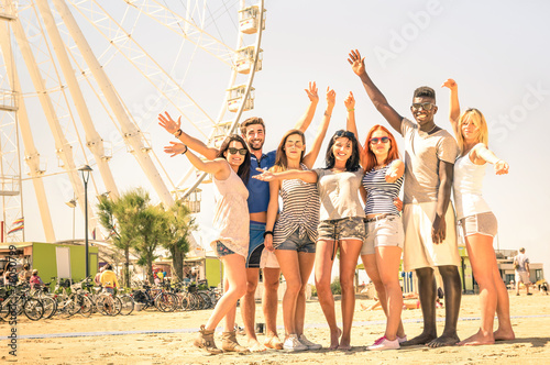 Group of multiracial happy friends cheering at ferris wheel