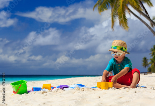 little boy playing on sand beach