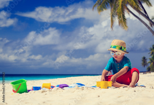 little boy playing on sand beach