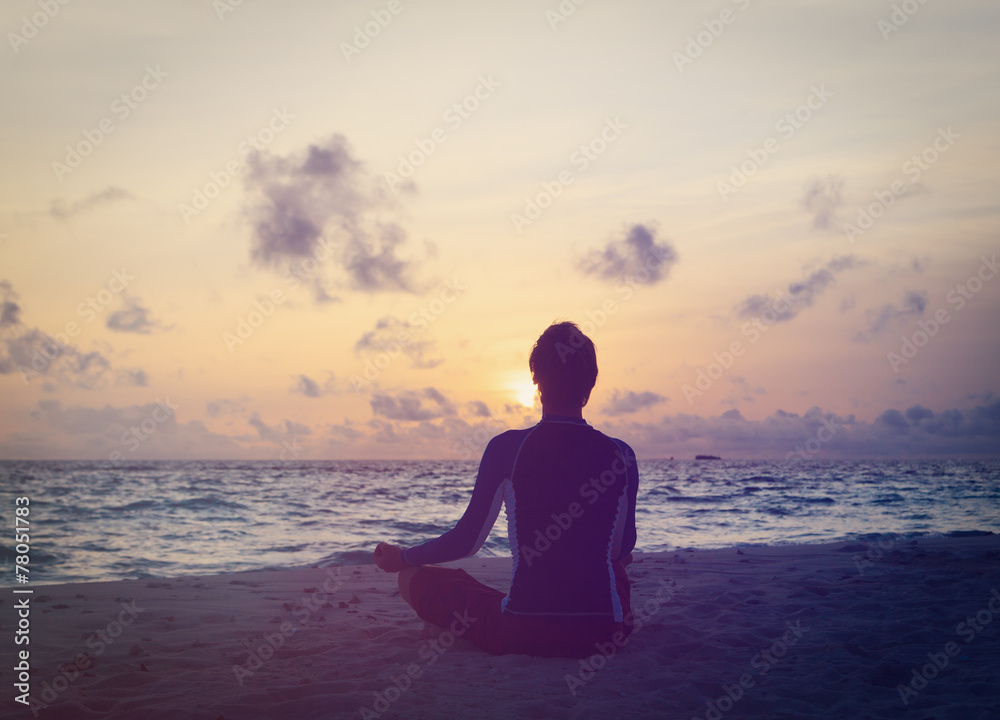 Silhouette of man meditating at sunset beach Silhouette of man meditating at sunset beach