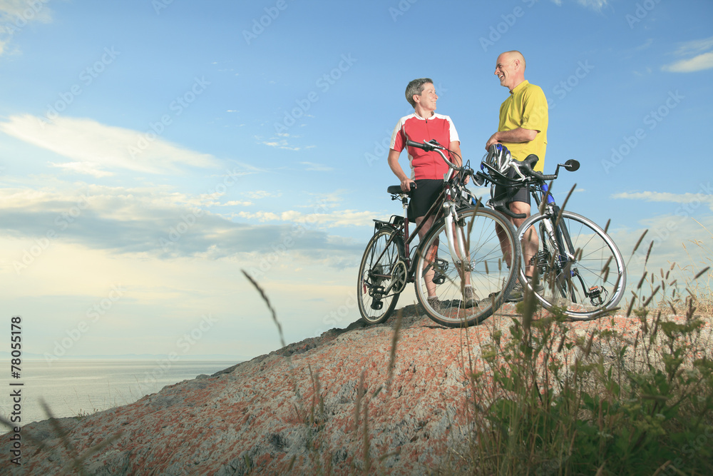 Fototapeta premium A senior man and a woman on bike at the sunset.