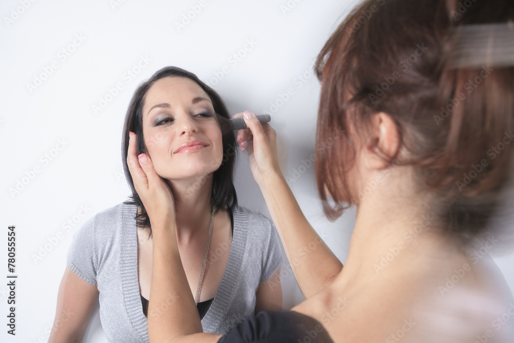 A makeup pro woman working on a fashion model A makeup pro woman working on a fashion model