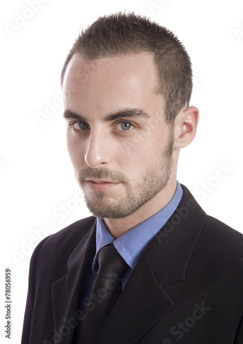 Concentrated young businessman using laptop and phone at office