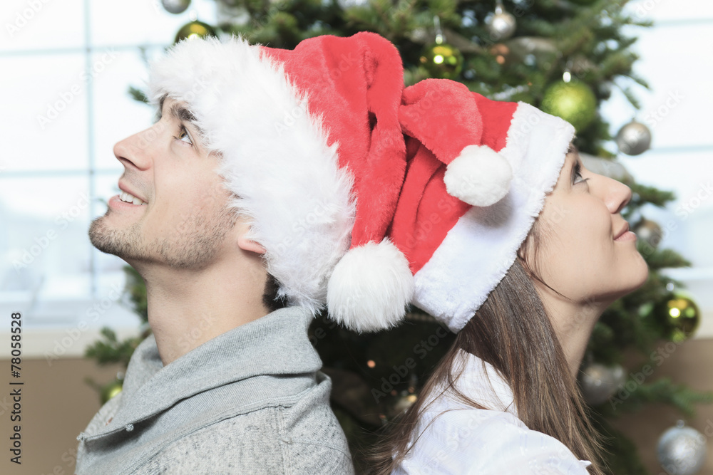 A Christmas Couple wearing Santa's Hats. Smiling Family Celebrat A Christmas Couple wearing Santa's Hats. Smiling Family Celebrat