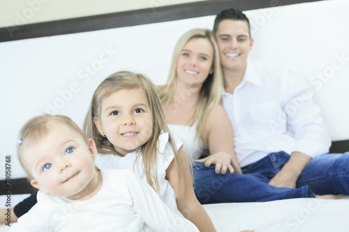 A happy family on white bed in the bedroom