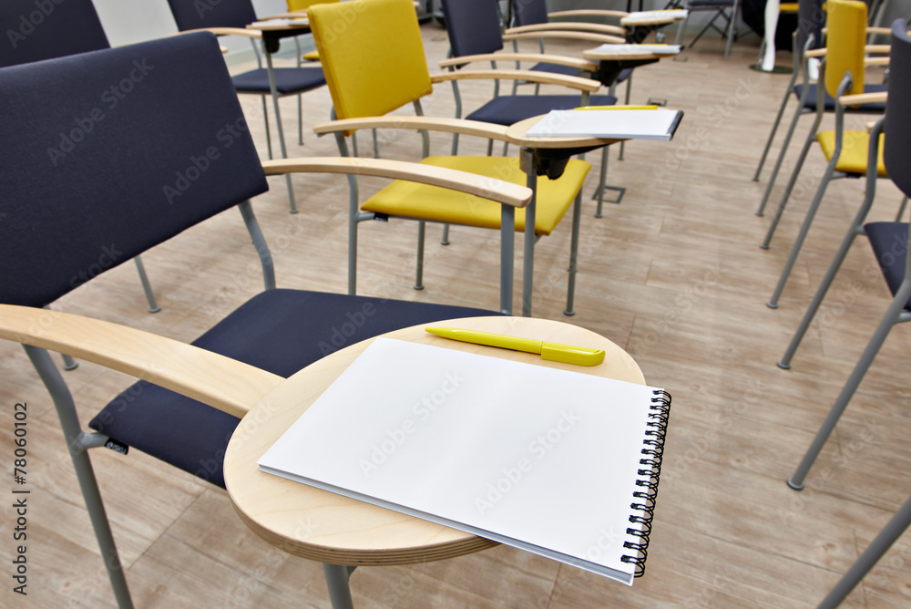 Chairs with notepads in empty classroom Chairs with notepads in empty classroom