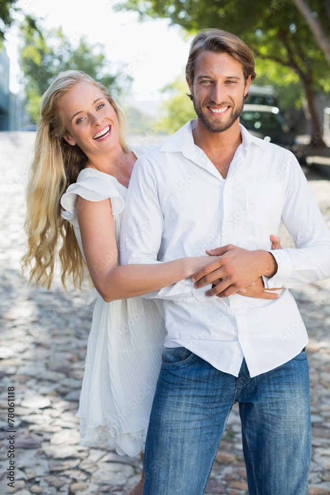 Attractive couple hugging and smiling at camera