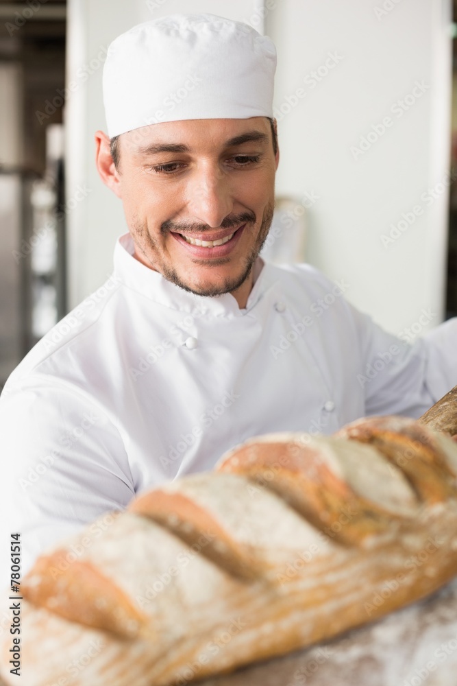 Happy baker taking out fresh loaf Happy baker taking out fresh loaf