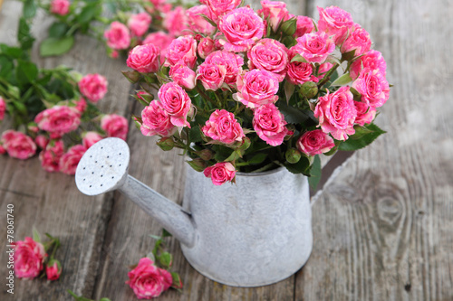 Fototapeta Naklejka Na Ścianę i Meble -  Bouquet of roses in a watering can