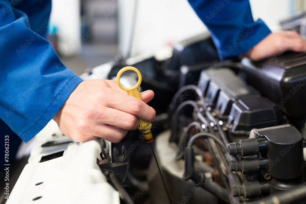 Mechanic testing oil in car