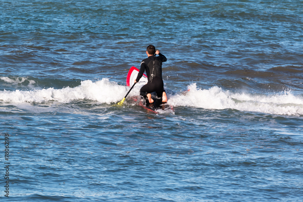 man paddleboarding on red board, surfer man paddleboarding on red board, surfer