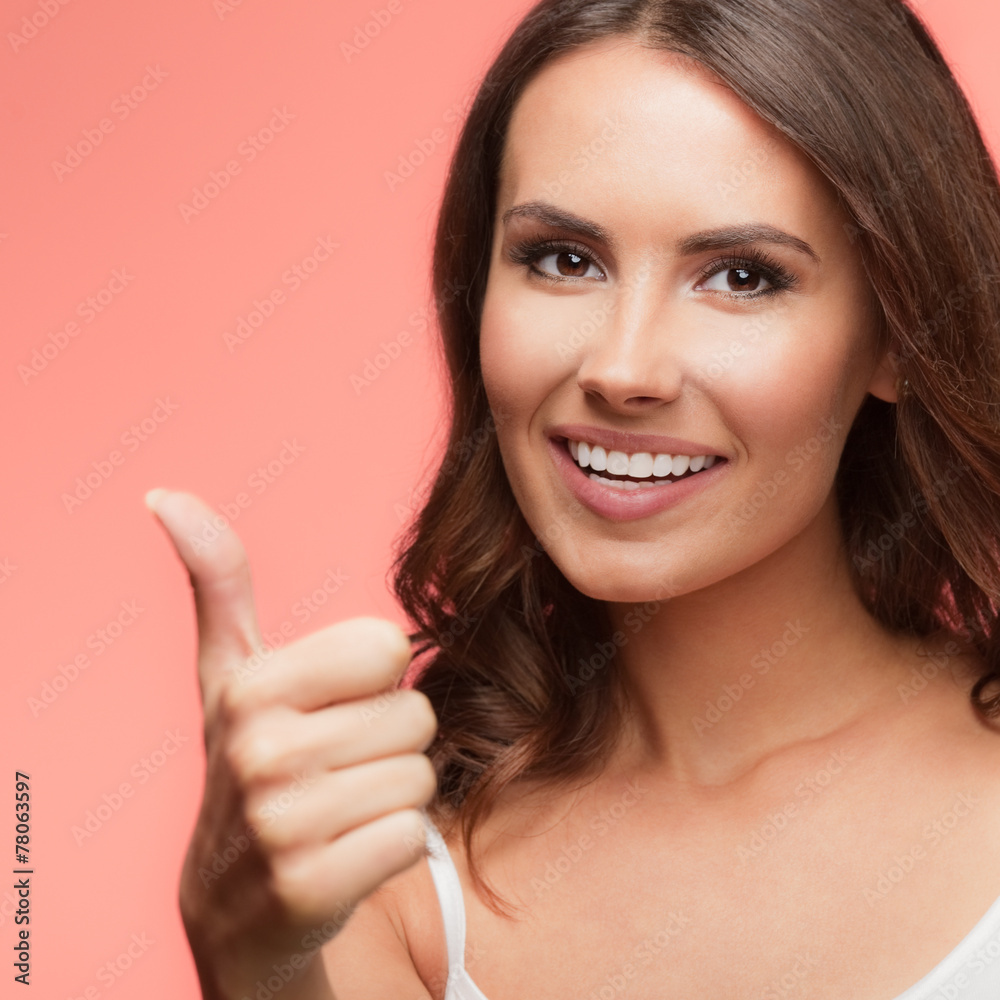 Portrait of happy woman showing thumb up gesture, on red Portrait of happy woman showing thumb up gesture, on red