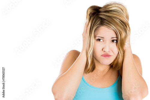 Portrait of young woman covering with hands her ears