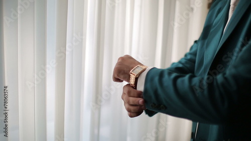 The man puts on a green jacket