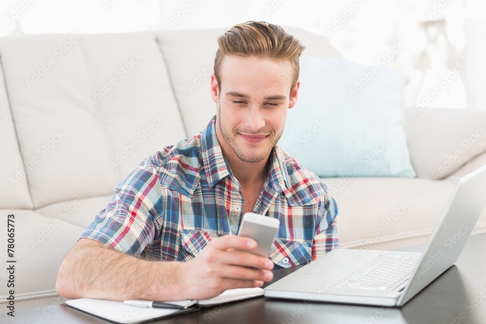 Smiling text messaging and using laptop Smiling text messaging and using laptop