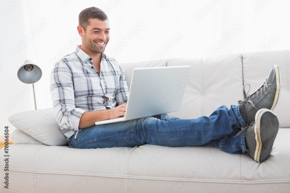Relaxing man on a sofa with a laptop Relaxing man on a sofa with a laptop