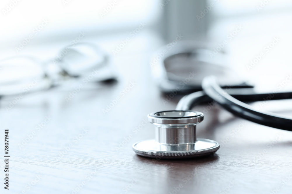 Stethoscope with digital tablet computer on wooden table and ba Stethoscope with digital tablet computer on wooden table and ba