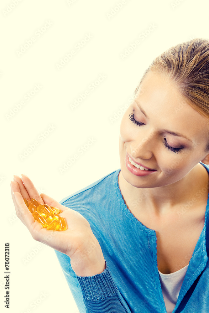 Portrait of young smiling woman with Omega 3 fish oil capsules Portrait of young smiling woman with Omega 3 fish oil capsules