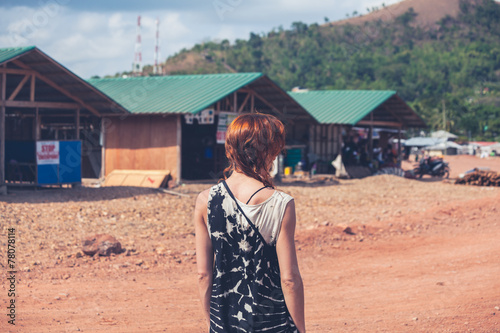 фотографія Young woman walking in a small town in developing country