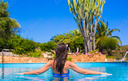 Beautiful young woman relaxing in swimming pool with cocktail © travnikovstudio